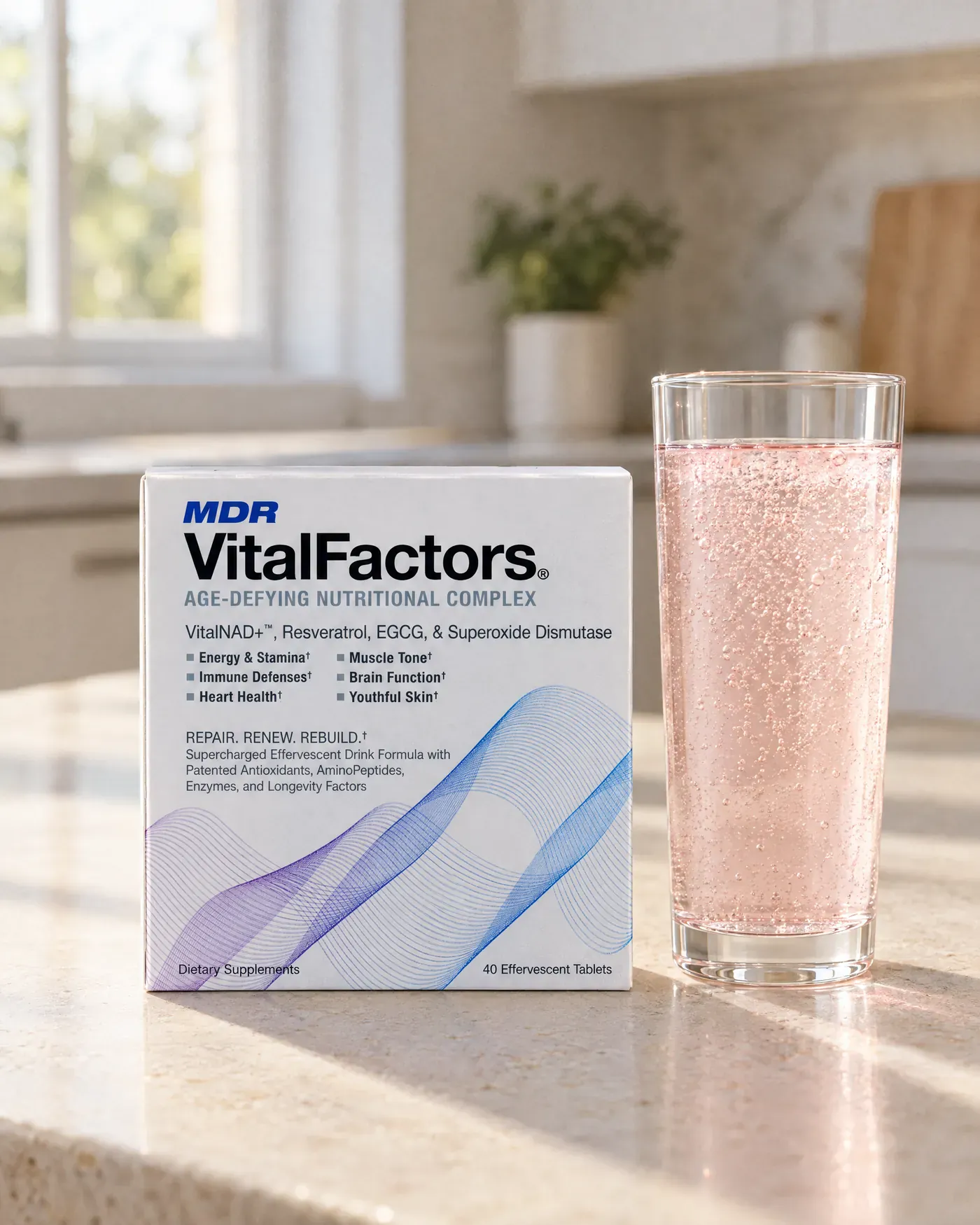 A VitalFactors box beside a tall glass of the pink sparkling drink on a kitchen counter in morning light