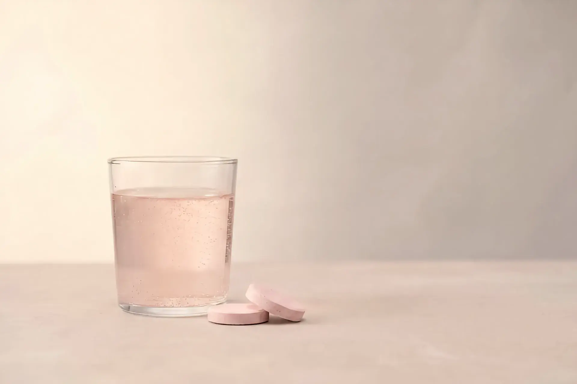 A glass of VitalFactors beside two tablets